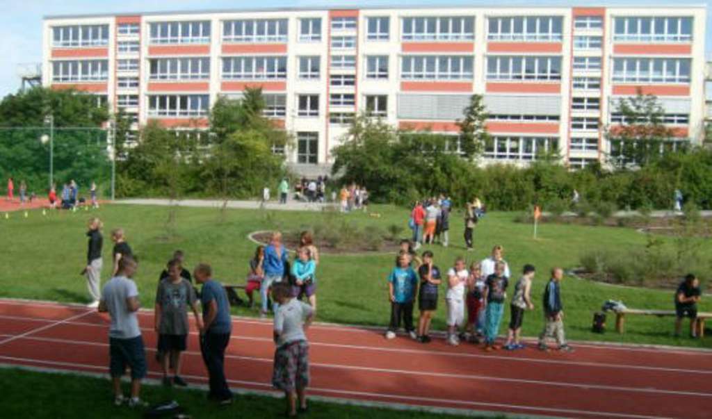 Das Gebäude der Norden-Schule mit großer Grünfläche und Sportanlage